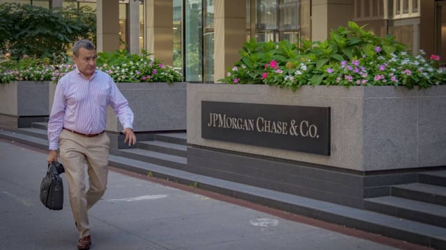 A person seen walking by the marquee at the main entrance to JPMorgan Chase headquarters building in Manhattan. 