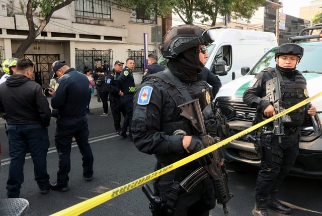 Mexican police stand guard at the scene of the daylight attack on a busy avenue