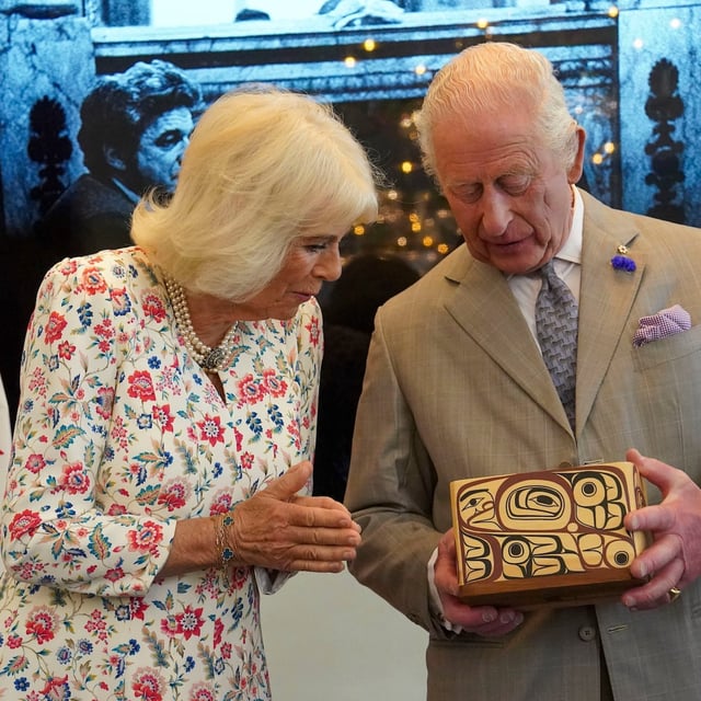 Britain's King Charles and Queen Camilla look at the Key to Canada House which was presented to the King by High Commissioner for Canada, Ralph Goodale, during a visit to Canada House to mark 100 years since it opened, in London, Tuesday, May 20, 2025. (Arthur Edwards/Pool via AP)
