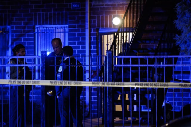Officers stand outside a residence one block south of the scene where a 13-year-old boy was fatally shot on the 500 block of West 65th Place in the Englewood neighborhood on March 24, 2025. (Armando L. Sanchez/Chicago Tribune)