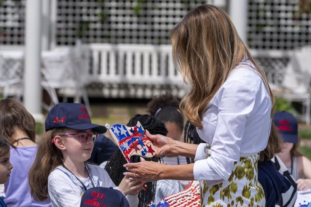 First lady Melania Trump looks at a decorated flag as she participates in flag decorating during a Take Our Child to Work Day event in the Jacqueline Kennedy Garden at the White House, Tuesday, May 20, 2025, in Washington. (AP Photo/Alex Brandon)