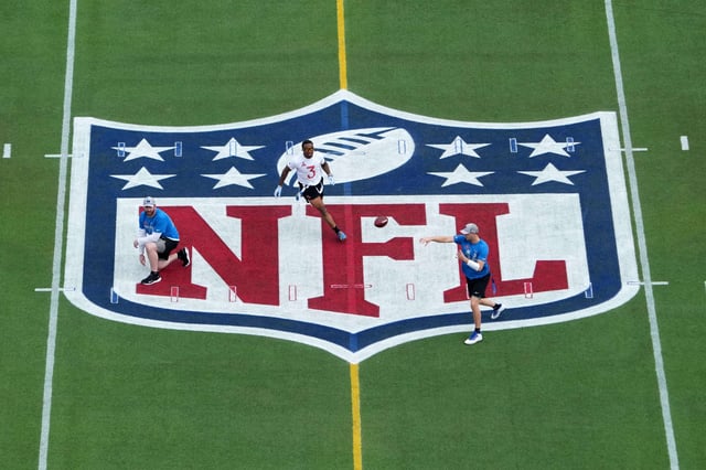 Feb 2, 2025; Orlando, FL, USA; A general overall view as NFC quarterback Jared Goff of the Detroit Lions (16) throws the ball on the NFL shield logo at midfield under pressure from AFC safety Derwin James of the Los Angeles Chargers (3) during the 2025 Pro Bowl Games at Camping World Stadium. Mandatory Credit: Kirby Lee-Imagn Images
