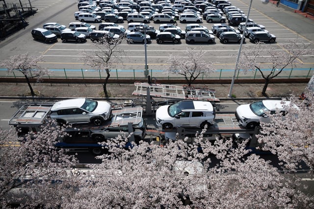 A car carrier transporting vehicles made by Kia Motors, which is part of South Korea's biggest automaker company Hyundai Motor, travels past blossoming cherry trees near Pyeongtaek port in Pyeongtaek, South Korea, April 15, 2025.   REUTERS/Kim Hong-Ji/File Photo