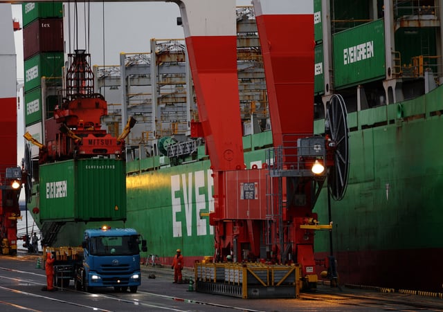 Workers load a container on a cargo ship at an industrial port in Tokyo, Japan April 3, 2025. REUTERS/Kim Kyung-Hoon