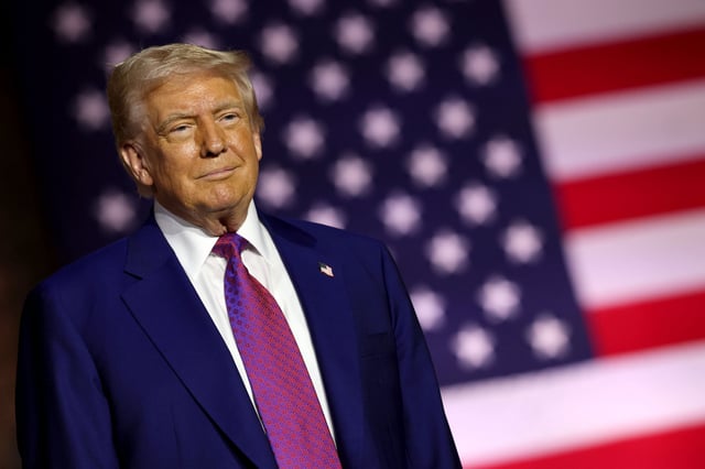 President Donald J. Trump is seen standing on stage as he tours the Al Udeid Air Base on May 15, 2025, in Doha, Qatar. (Photo by Win McNamee/Getty Images)