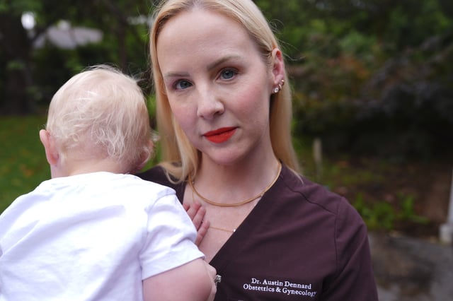 Dr. Austin Dennard holds her son as she poses for a portrait at her home in Dallas, Friday, May 2, 2025. (AP Photo/LM Otero)