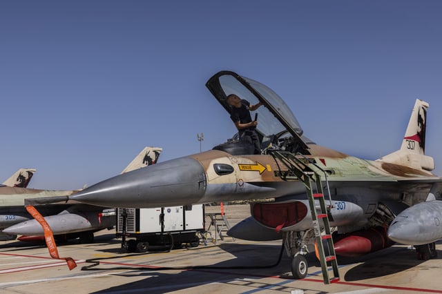 An Israeli F-16 technician checks an air force fighter jet during the bi-annual multi-national aerial exercise known as the Blue Flag, at Ovda airbase near Eilat, southern Israel, Sunday, Oct. 24, 2021.