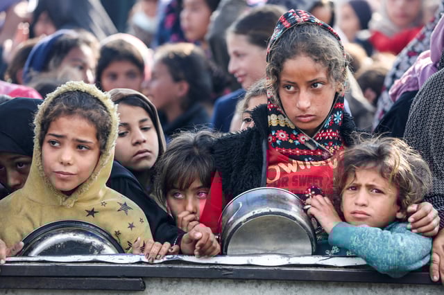 Palestinians gather to receive food cooked by a charity kitchen, before a ceasefire between Hamas and Israel takes effect, in Khan Younis, in the southern Gaza Strip, January 17, 2025. REUTERS/Hatem Khaled/File Photo