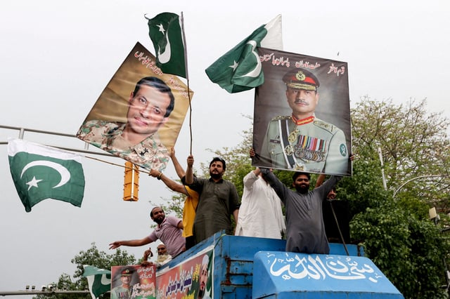 People carry posters showing the pictures of Chief of Army Staff of Pakistan Asim Munir, (R) along with Ahmed Sharif Chaudhry, Director General of Inter-Service Public Relations wing of Pakistan Armed Forces, as they take part in a rally in support of Pakistan Army, a day after the ceasefire announcement between India and Pakistan, in Lahore, Pakistan, May 11, 2025. REUTERS/Mohsin Raza /File Photo