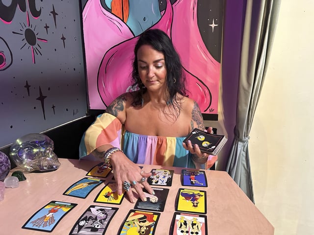 FILE - Ashley Branton lays out tarot cards in the back of her shop, Velvet Witch, in Norfolk, Va., June 13, 2024. (AP Photo/Ben Finley, File)