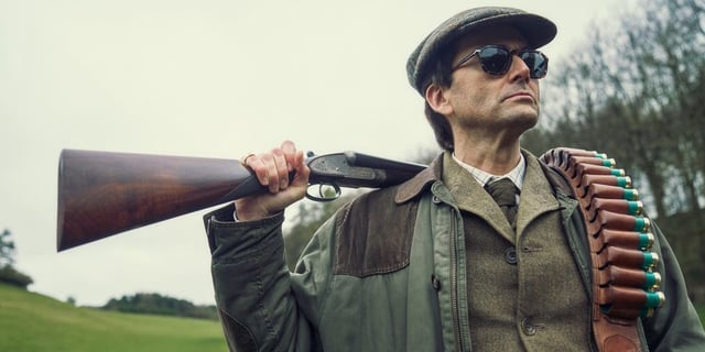 David Tennant holding a rifle in Rivals