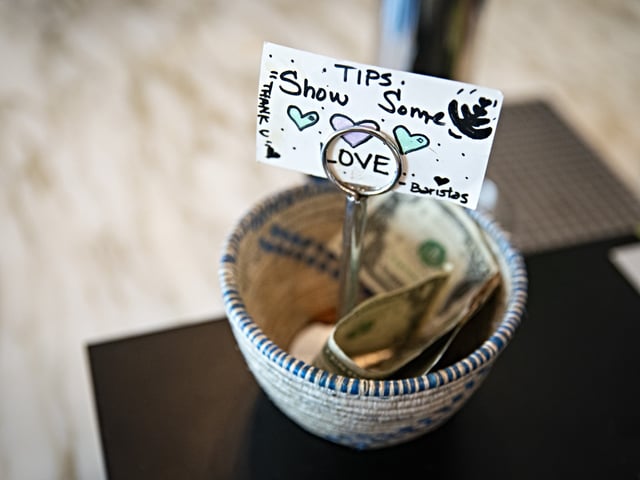 A tip jar at a coffee shop in the Union Market district in Washington, DC, US, on Friday, Sept. 8, 2023. US employment gains will slow significantly and be more concentrated across few sectors in the decade through 2032 as population growth moderates, fresh government estimates show. Photographer: Al Drago/Bloomberg