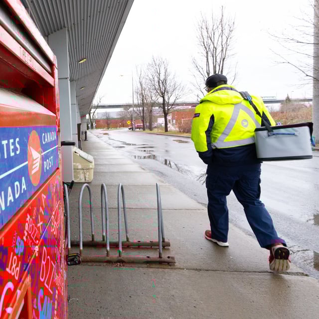 A Canada Post worker arrives for work in Montreal on Tuesday, Dec.17, 2024. THE CANADIAN PRESS/Christinne Muschi