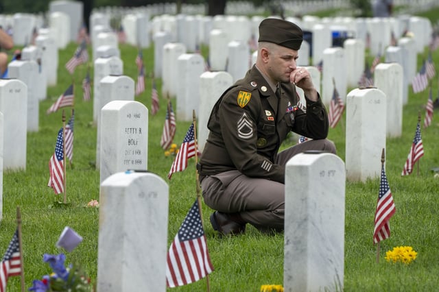 FILE - A member of the Army visits Section 60 of Arlington National Cemetery, in Arlington, Va., Monday, May 27, 2024, on Memorial Day. (AP Photo/Jacquelyn Martin, File)