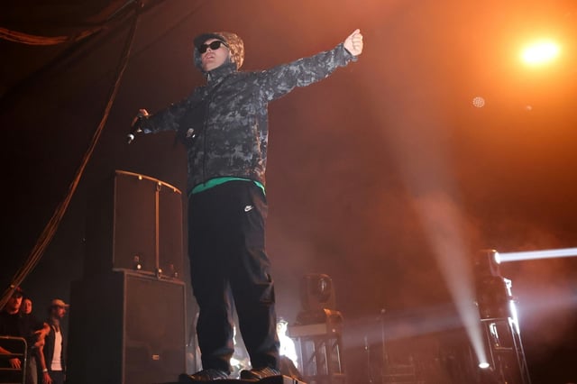 Nach dem Zeigen einer Hisbollah-Fahne bei einem Konzert in London wird einem Mitglied der irischen Rap-Gruppe Kneecap ein Verstoß gegen die Anti-Terror-Gesetzgebung vorgeworfen.