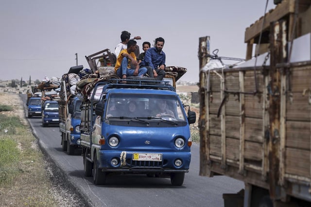 Trucks carrying around 60 displaced families arrive in their village after more than five years in the Atmeh camps near the Syrian-Turkish border, in Kafr Sijna, south of Idlib, Syria, Sunday, May 18, 2025. (AP Photo/Ghaith Alsayed)
