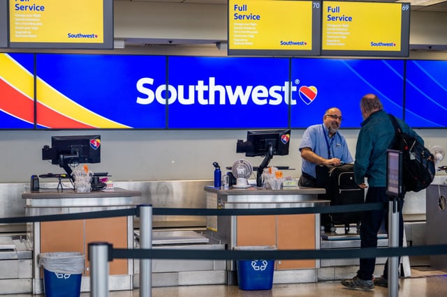 AUSTIN, TEXAS - APRIL 18: A Southwest Airlines employee assists a passenger during their check-in at the Austin-Bergstrom International Airport on April 18, 2023 in Austin, Texas. Southwest Airlines suffered a brief disruption in operations earlier this morning after a computer firewall issue forced the company to delay many of its flights. (Photo by Brandon Bell/Getty Images)