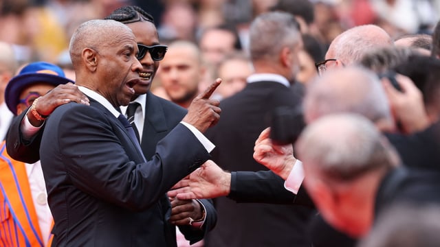 Denzel Washington argues with a photographer next to US singer and actor ASAP Rocky as they arrive for the screening of the film Highest 2 Lowest at the 78th edition of the Cannes Film Festival, on May 19, 2025. (Photo by Sameer AL-DOUMY / AFP)