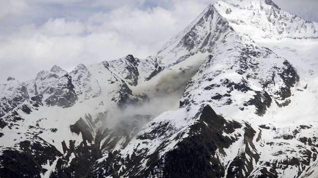 Schweiz, Blatten: Staub von einem Felssturz steigt auf, an einer Flanke des Berges Bietschhorn im Lötschental, aufgenommen von der Ortschaft Wiler.