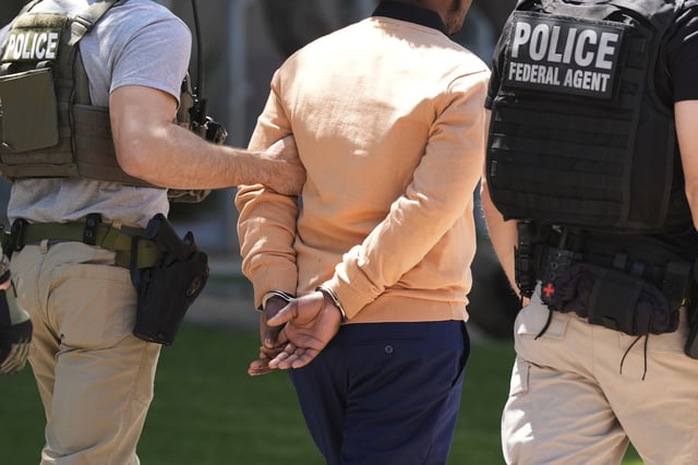 Federal agents take a person into custody after an immigration court hearing outside an immigration court, Wednesday, May 21, 2025, in Phoenix. (AP Photo/Ross D. Franklin)