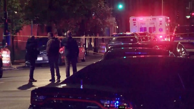 An ambulance and police vehicles line a street where two Israeli embassy staff were shot dead near the Capital Jewish Museum in Washington, DC