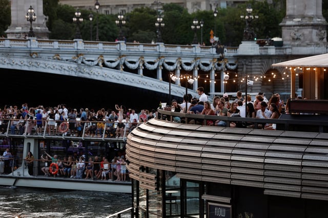 People enjoy the sunset on a floating restaurant on the River Seine in Paris, France, June 25, 2023. REUTERS/Benoit Tessier/ File Photo
