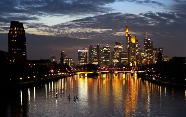 Stand-up paddlers are seen on river Main during sun set behind the skyline with the banking district in Frankfurt, Germany, October 18, 2021.  REUTERS/Kai Pfaffenbach/File Photo