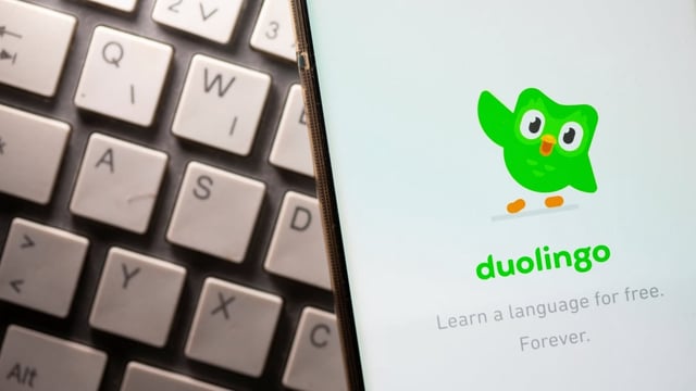 A smartphone showing the Duolingo app is seen in this June 2021 photo. Duolingo's founder and CEO is sparking controversy with recent statements that AI should replace teachers since it teaches better than humans, but that schools will still exist for childcare. 
