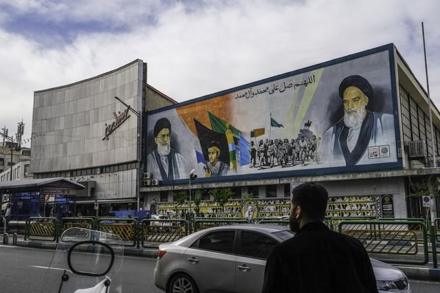 Iranians pass by a mural that depicts the two Supreme Leaders of Iran near Enghelab (Revolution) Square in downtown Tehran, Iran on April 8, 2025, four days before the first round of indirect nuclear negotiations with President Trump&#39;s administration hosted and mediated by Oman.