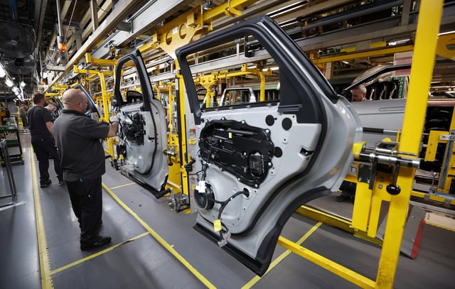 Staff members assemble door panels on the production line at Jaguar Land Rover's Halewood factory in Liverpool, Britain, December 6, 2022. REUTERS/Phil Noble/File Photo