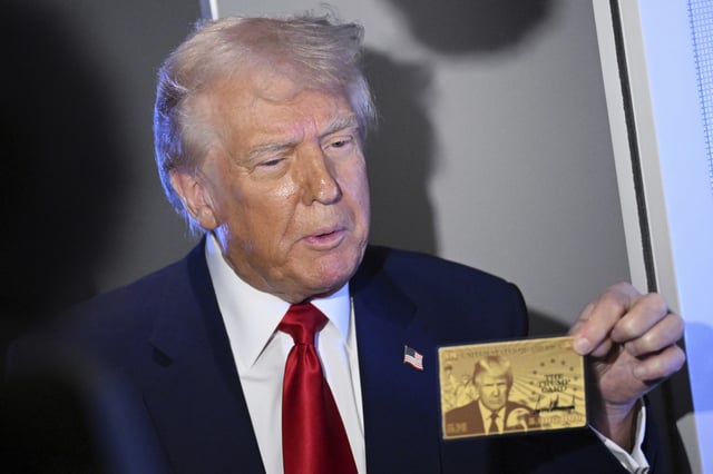 President Donald Trump holds up the $5 million gold card as he speaks to reporters while in flight on board Air Force One, en route to Miami, Thursday, April 3, 2025.