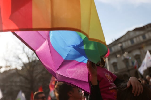 A child of a same-sex couple touches the LGBT flag at a protest after Italy's right-wing government told Milan's city council to stop registering same-sex parents' children in Milan, Italy March 18, 2023. REUTERS/Claudia Greco/File Photo