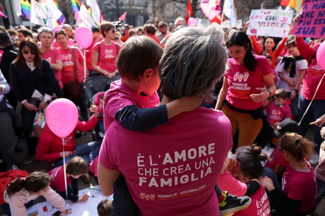 A child of a same-sex couple is carried by their parent at a protest after Italy's right-wing government told Milan's city council to stop registering same-sex parents' children in Milan, Italy March 18, 2023. REUTERS/Claudia Greco/File Photo