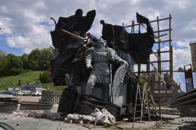 Municipal workers remove the cover that protected a monument of Kyiv legendary founders from Russian missile attacks on the fourth year of Russia-Ukraine war on the country's main square in Kyiv, Ukraine, Wednesday, May 21, 2025. (AP Photo/Efrem Lukatsky)(