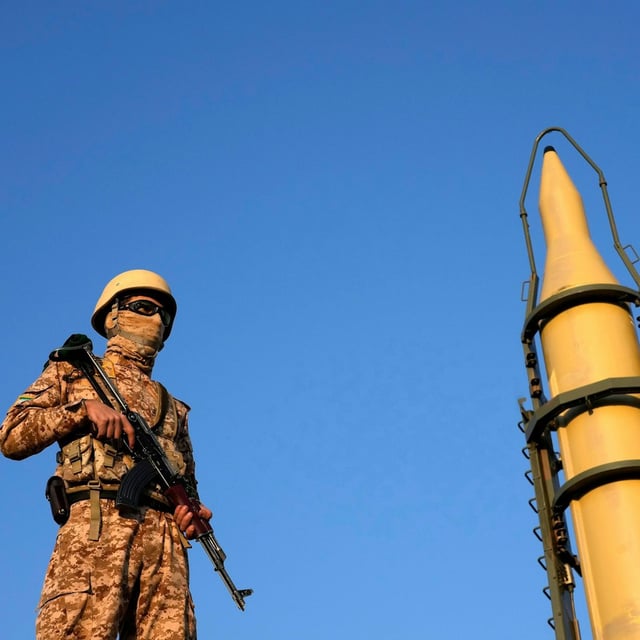 Ein Angehöriger der iranischen Streitkräfte steht während einer Parade in Teheran vor einer Rakete Wache.