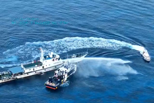 This screen capture shows a Chinese coast guard ship cutting across the bow of a Philippine fisheries bureau vessel and deploying its water cannon near Sandy Cay, a disputed feature in the South China Sea.