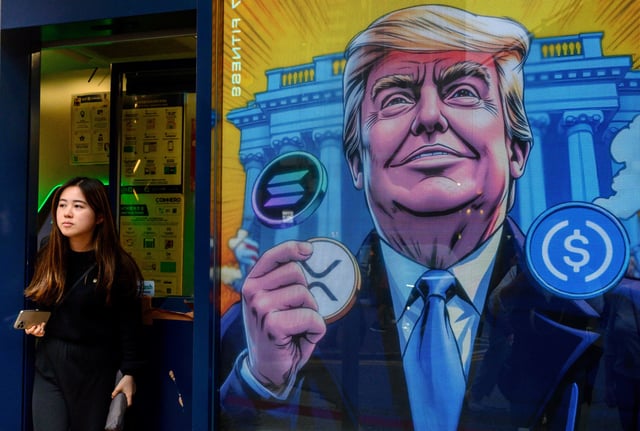 People walk past a cryptocurrency exchange office with a screen featuring US President Donald Trump holding cryptocurrency coins in Hong Kong on March 12, 2025.