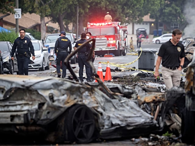 Investigators look through the site where a small plane crashed  into San Diego, California, residential street on May 22, 2025. The Federal Aviation Authority said a Cessna 550 crashed at around 3:45 am local time. The neighborhood is close to the Montgomery-Gibbs Executive Airport. The crash left a "gigantic debris field" and damaged some 15 homes and parked cars, ABC News quoted the San Diego assistant fire chief as saying. (Photo by Sandy Huffaker / AFP)