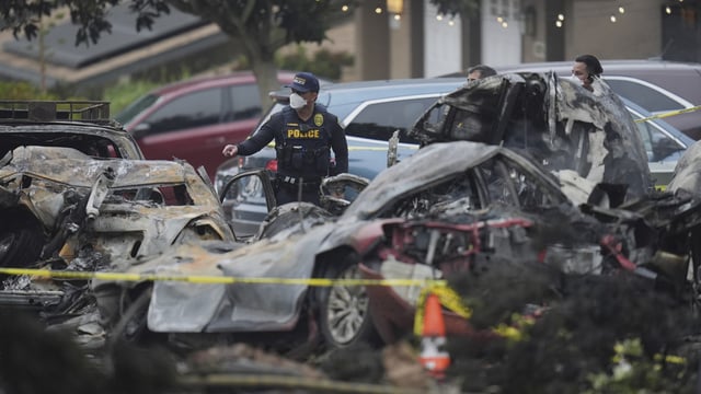 Authorities work the scene where a small plane crashed into a San Diego neighborhood, setting several homes on fire and forcing evacuations along several blocks early Thursday, May 22, 2025. (AP Photo/Gregory Bull)