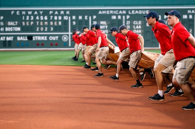 The Fenway Park grounds crew brings out the tarp during a rain-delay start to the baseball game between the Boston Red Sox and the Baltimore Orioles, Saturday, Sept. 9, 2023, in Boston. (AP Photo/Michael Dwyer)