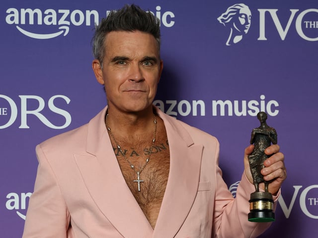 Robbie Williams poses for a portrait holding his Music Icon award at the Ivor Novello Awards in London, Britain, May 22, 2025. REUTERS/Toby Melville