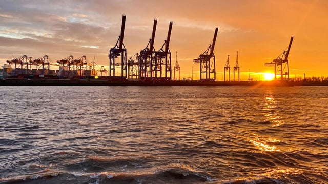 Sonnenuntergang hinter den Verladekränen des Burchardtkai, Hamburger Hafen.