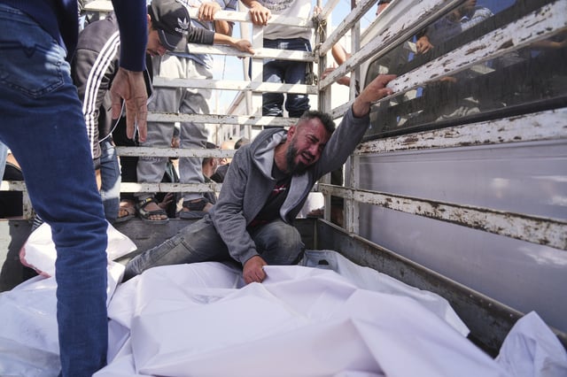 Osama Abu Mosabbah, mourns his wife and two children who were killed in an Israeli army airstrike on the Gaza Strip, during their funeral at Al-Aqsa Hospital in Deir al-Balah, Gaza, Tuesday, May 20, 2025. (AP Photo/Abdel Kareem Hana)