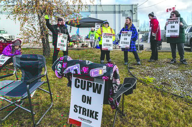 CUPW members wave to honking trucks as they strike along Penn Road in front of the mail sorting facility last November. A second strike was averted, perhaps temporarily, Thursday, May 22, 2025.