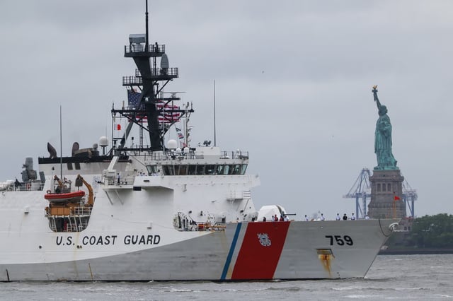 A U.S. Coast Guard vessel cruises through New York Harbor near the Statue of Liberty as part of Fleet Week on May 21, 2025.
