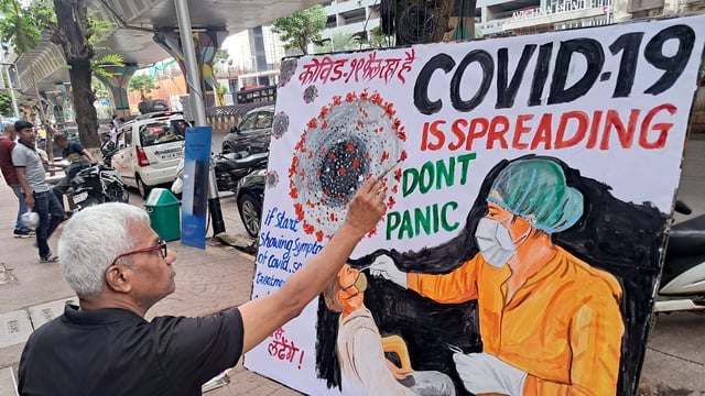 A teacher of the Gurukul School of Art makes an awareness painting of COVID-19, in Mumbai on Wednesday.