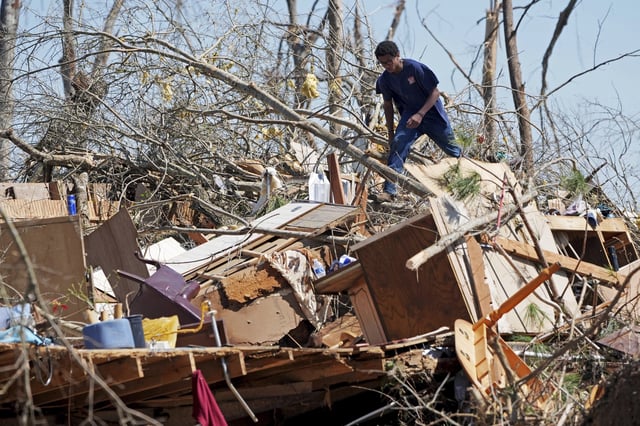 FILE - Family friend Trey Bridges, 16, climbs a mountain of tornado debris to help the Blansett family recover items not destroyed by Saturday's tornado, Sunday, March 16, 2025, in Tylertown, Miss. (AP Photo/Rogelio V. Solis, File)