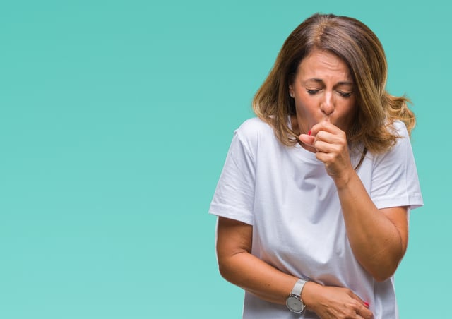 Middle age senior hispanic woman over isolated background feeling unwell and coughing as symptom for cold or bronchitis. Healthcare concept.