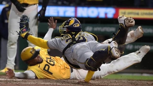 May 23, 2025; Pittsburgh, Pennsylvania, USA;  Milwaukee Brewers catcher William Contreras (24) dives in an attempt to tag Pittsburgh Pirates outfielder Alexander Canario (rear) out at home plate during the tenth inning at PNC Park. Canario was ruled out for leaving the baseline. Mandatory Credit: Charles LeClaire-Imagn Images