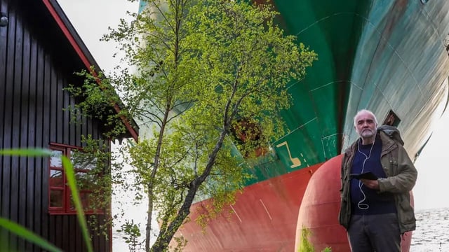 Johan Helberg pictured with the NCL Salten grounded next to his cabin. | NTB Scanpix via AP